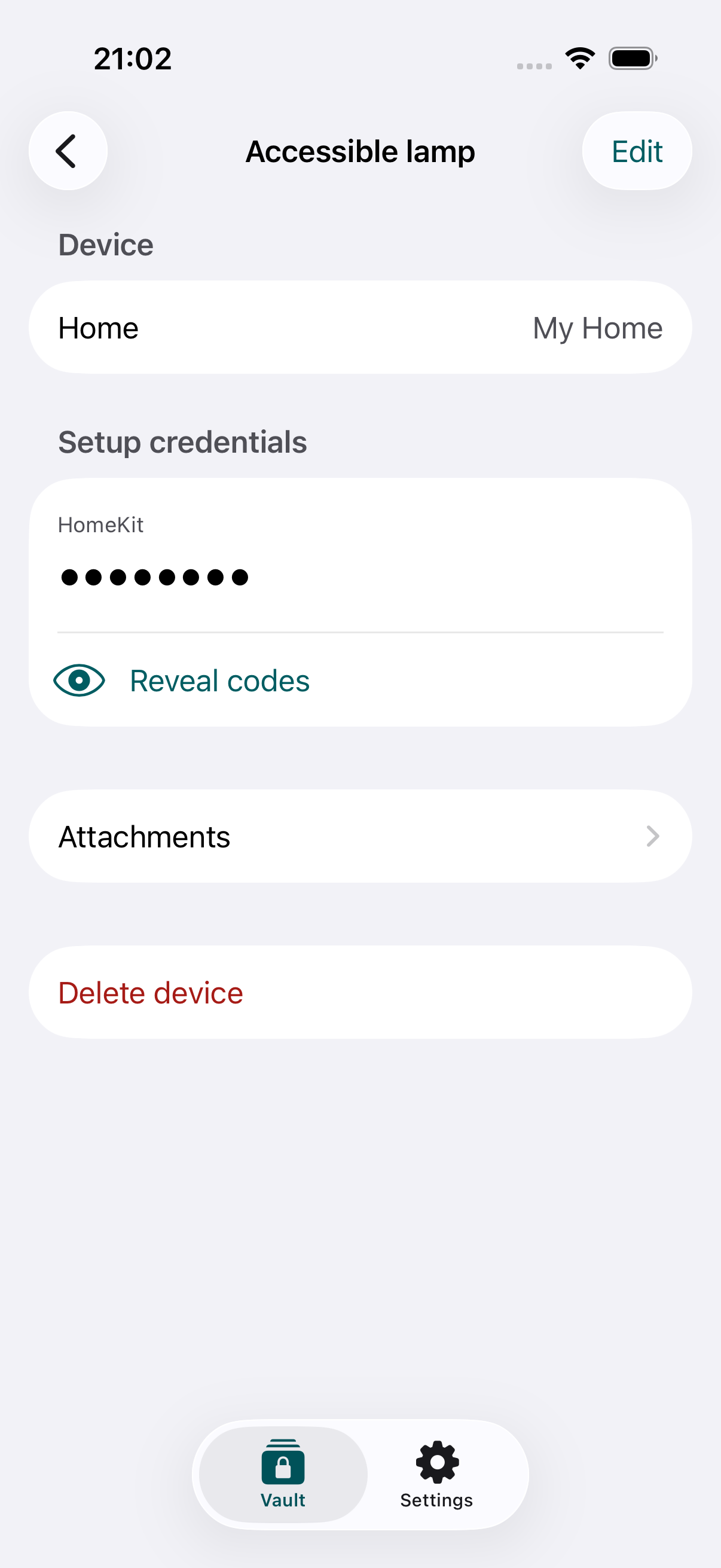 The iPhone app showing a saved example lamp, its hidden setup code, a Reveal codes button and attachments.